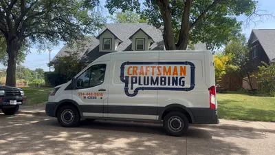 A Craftsman Plumbing van parked on a residential street in front of a home.