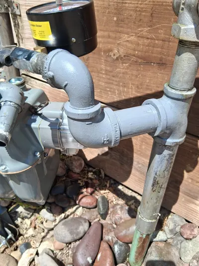 New black iron gas piping installed at the meter connection outside a home.