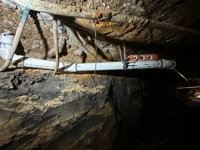 Setting pipe pitch and support during sewer line work.