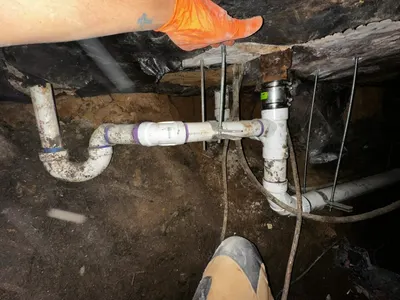 Install support sewer lines under house during sewer line work.