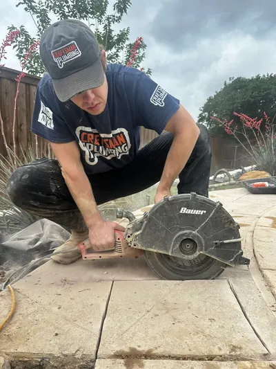 Cutting through concrete during a slab leak repair.