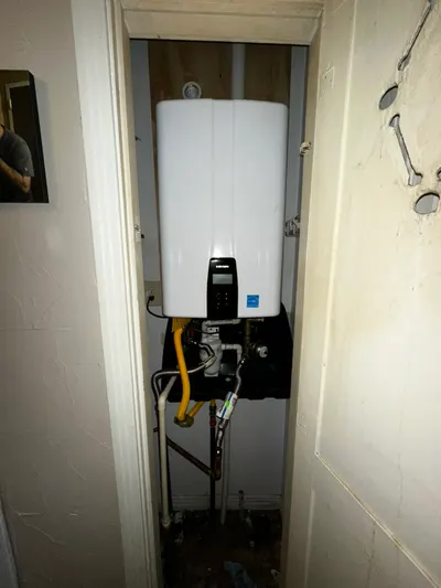 New tankless water heater in closet during a water heater installation.