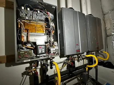 Three tankless water heaters during a water heater installation.