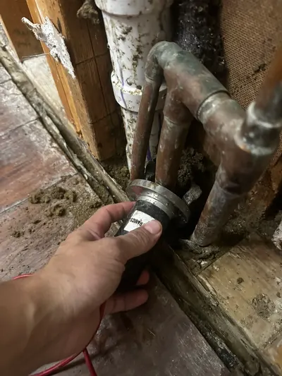 Removing broken pipe inside wall during a water line repair.