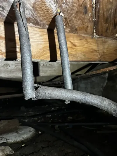 Insulated pipes under wooden floor during a whole-house repipe.